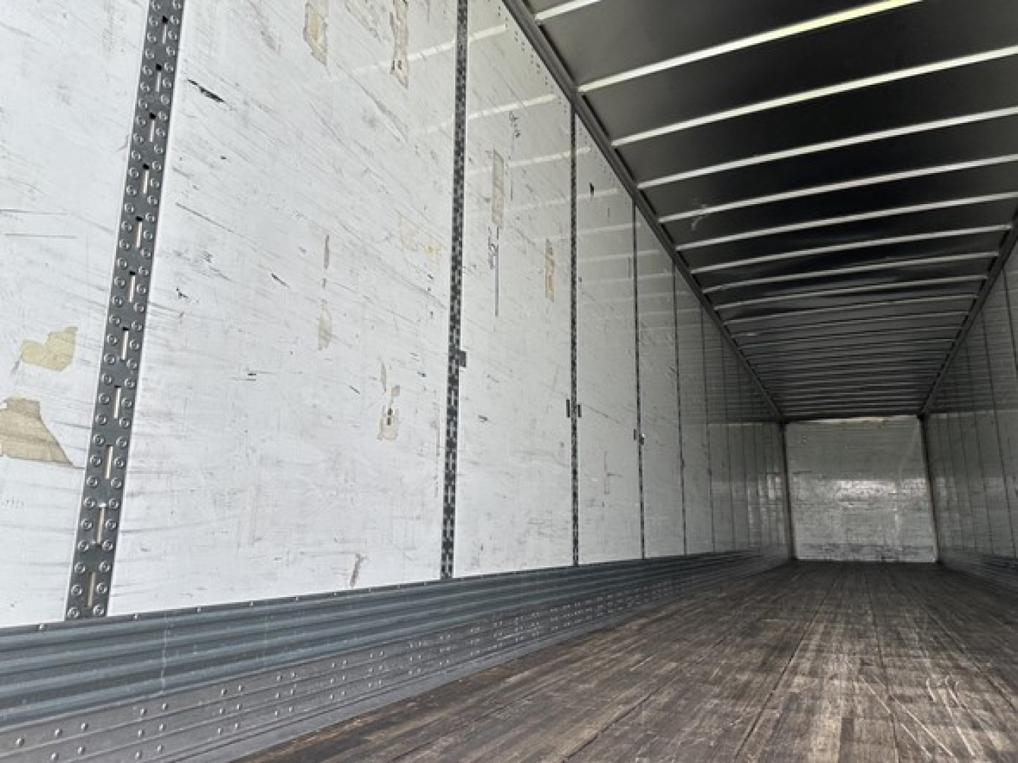 Trailer interior showing metal sidewall rails and wooden floor of a 53' dry van with Duraplate sides.