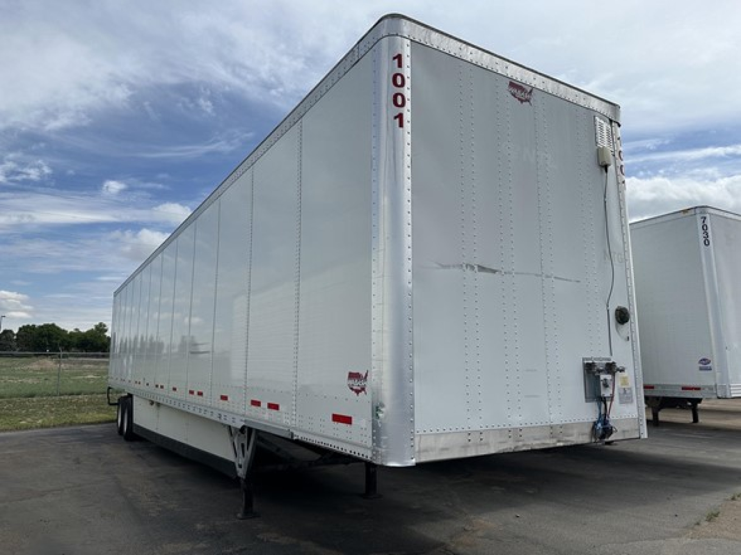 Trailer side and front of a 2022 Wabash Duraplate 53' air ride dry van with chrome nose, vertical corners, metal siding, and landing gear visible