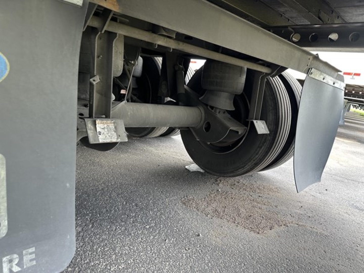 Trailer undercarriage showing wheel hub, suspension, and mud flaps of a 53' Wabash Duraplate dry van trailer.