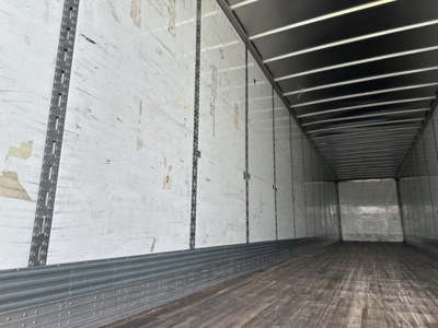 Trailer interior showing metal sidewall rails and wooden floor of a 53' dry van with Duraplate sides.