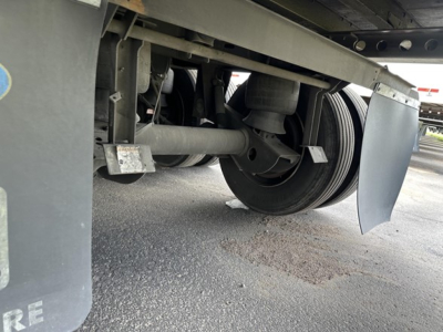 Trailer undercarriage showing wheel hub, suspension, and mud flaps of a 53' Wabash Duraplate dry van trailer.