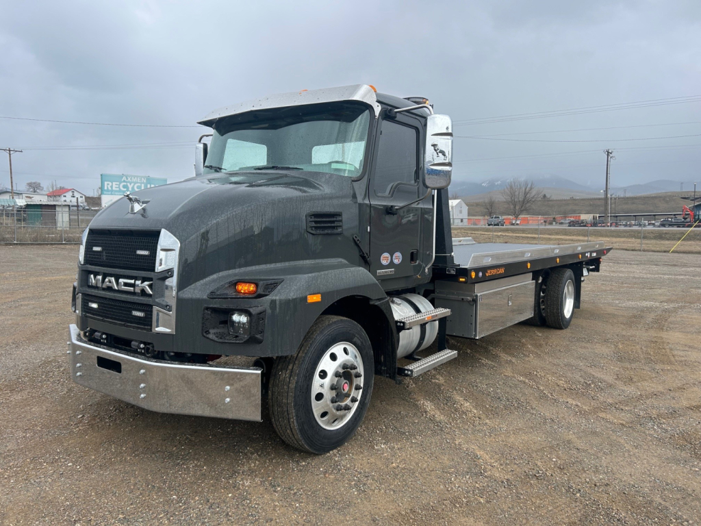 Mack MD6 tow truck/rollback showing front grille with Mack badge and flatbed bed.