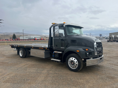 Mack MD6 rollback truck showing cab and flatbed with metal bumper and orange clearance lights, side view with VIN and inventory details not visible
