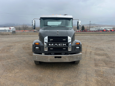 Front view of a black Mack MD6 rollback truck showing bold grille, large bumper, and daytime running lights.