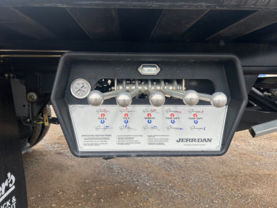 Panel with controls and label on Mack MD6 rollback truck showing levers and manifold with instruction text