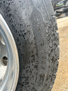 Tire sidewall with 255/70R22.5 and Load Range D on a Mack MD6 rollback truck. Visible markings include 255/70R22.5, 10PR, and tubed lettering along the tread.