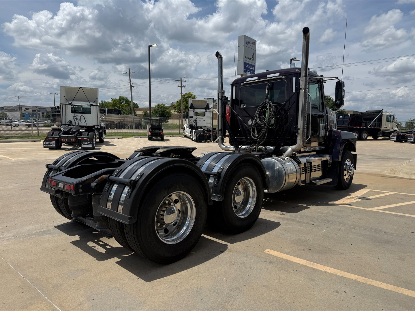 Mack PI64T conventional daycab tractor chassis rear and fuel tanks visible with dual rear axles.