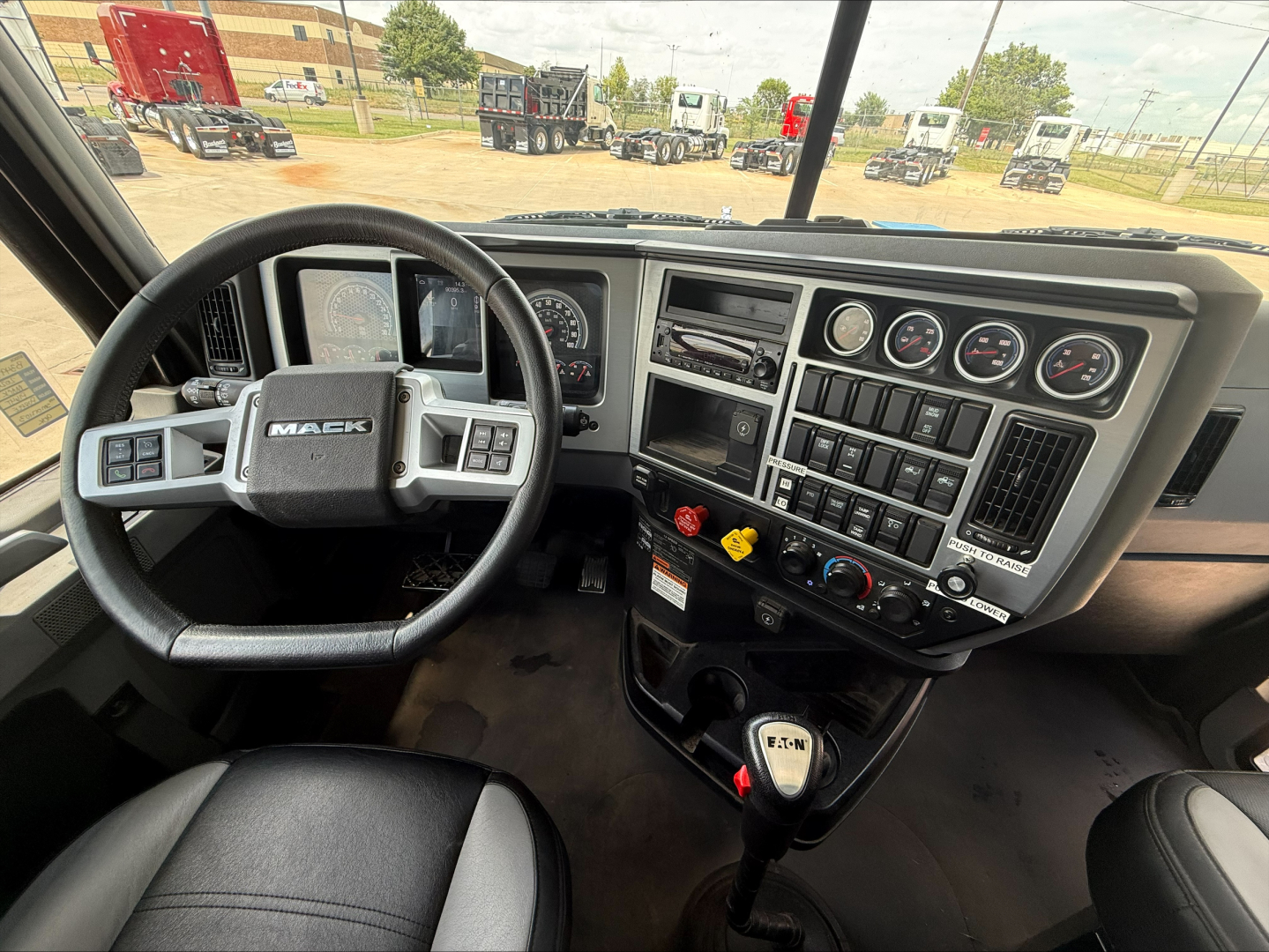 Mack PI64T truck interior dashboard and steering wheel view with multiple gauges and controls.