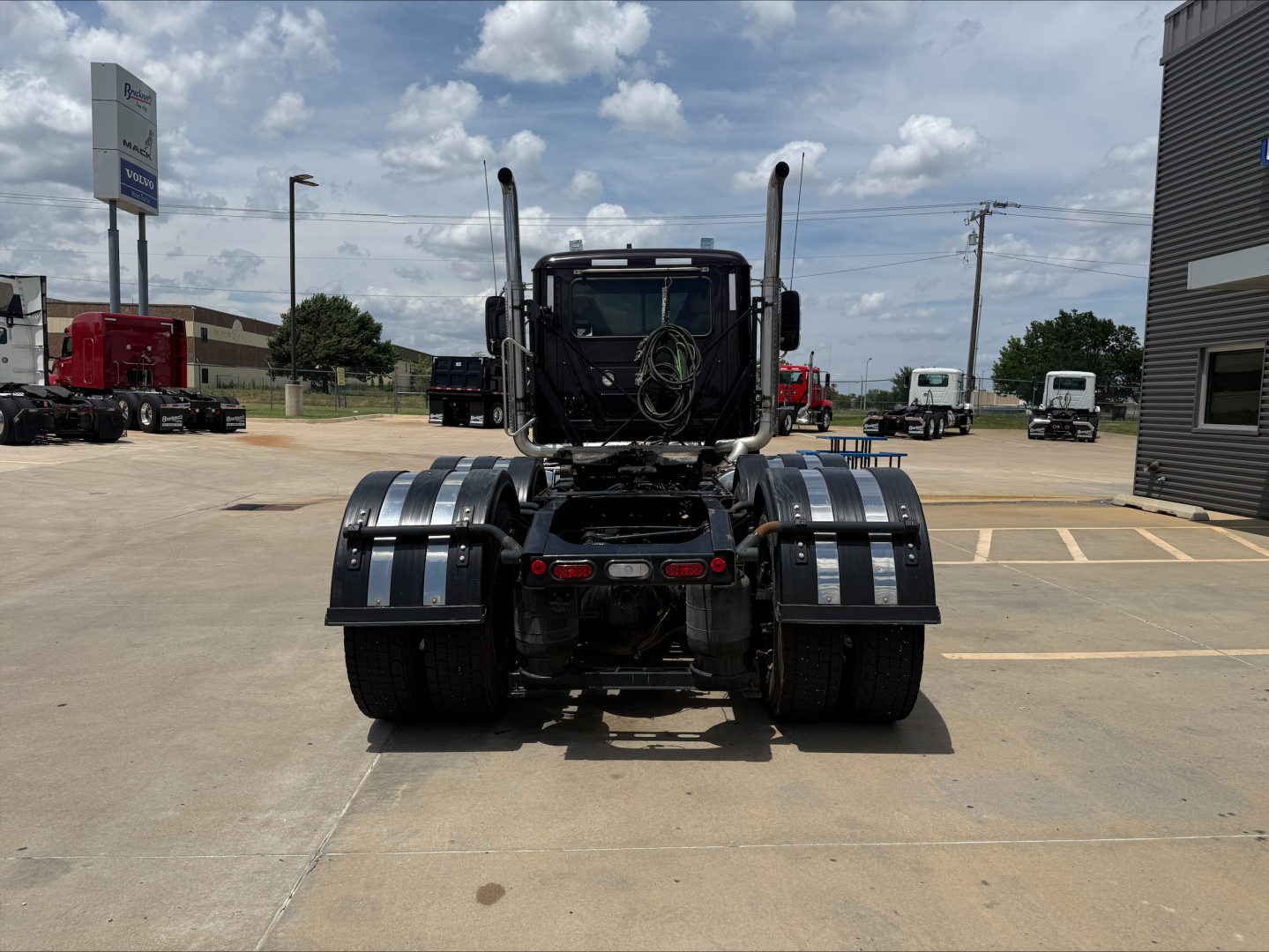 Mack PI64T tractor rear view showing dual rear axles with chrome fenders and fifth-wheel area.