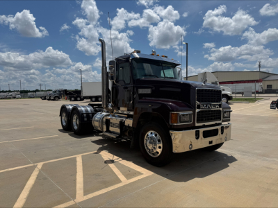 Mack PI64T conventional daycab truck in a parking lot showing front and side view with chrome bumper and dual rear axles.