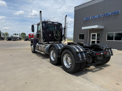 Mack PI64T tractor in front of a Used Truck Center building; rear view shows chassis and dual rear axles with fifth-wheel area and air lines; VIN sticker and dealership signage partially visible.