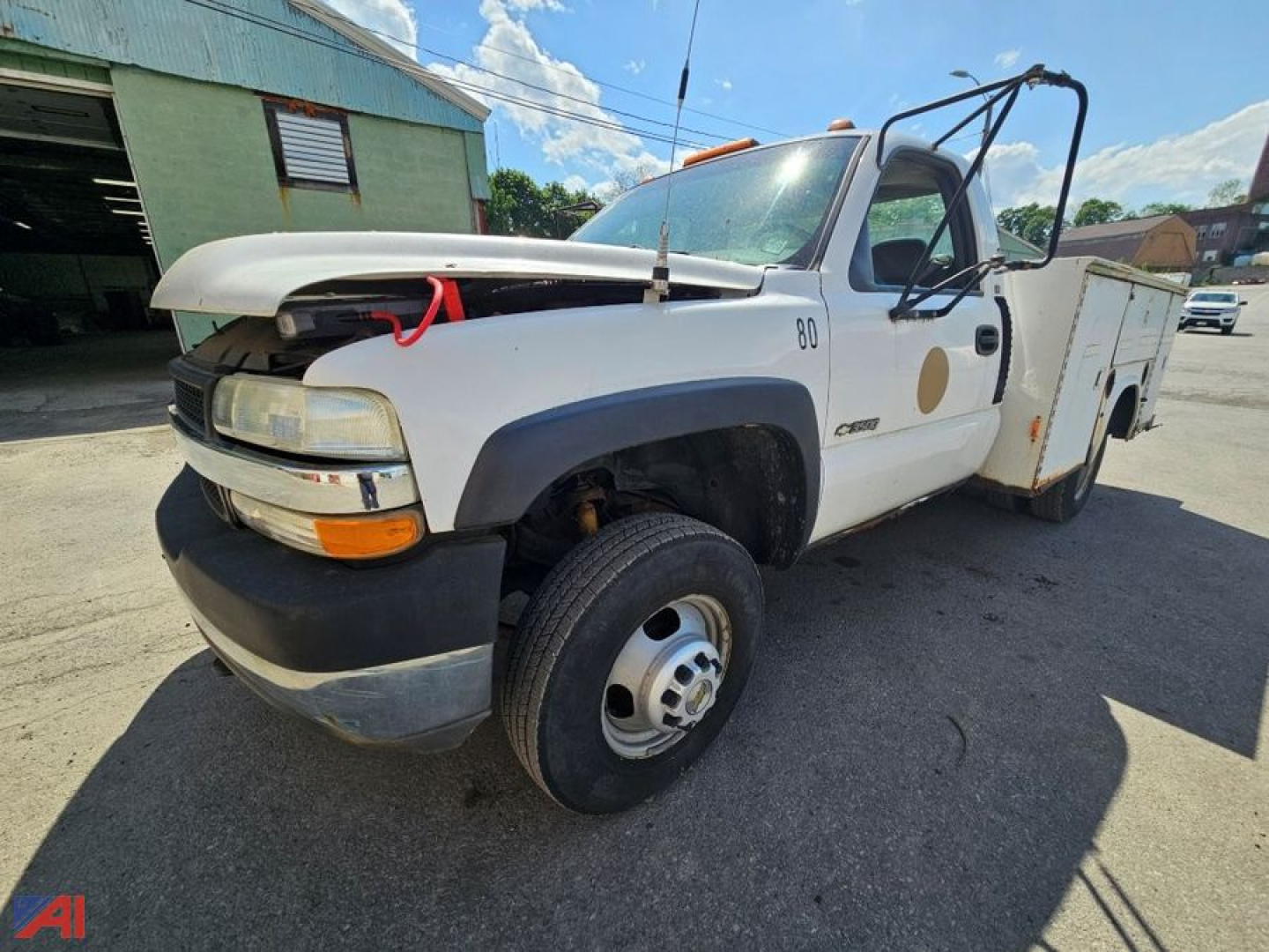Truck showing front-left view of a white 2002 Chevrolet Silverado 3500 utility/service truck with raised hood, front bumper guard, and utility bed.