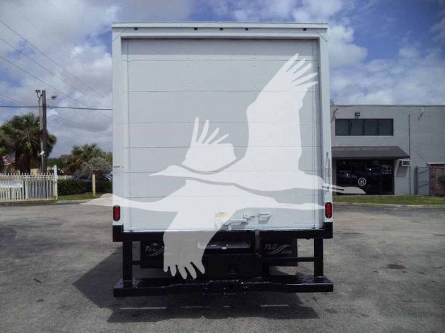 Rear view of a white Ford E-series box truck showing back doors and hitch area.