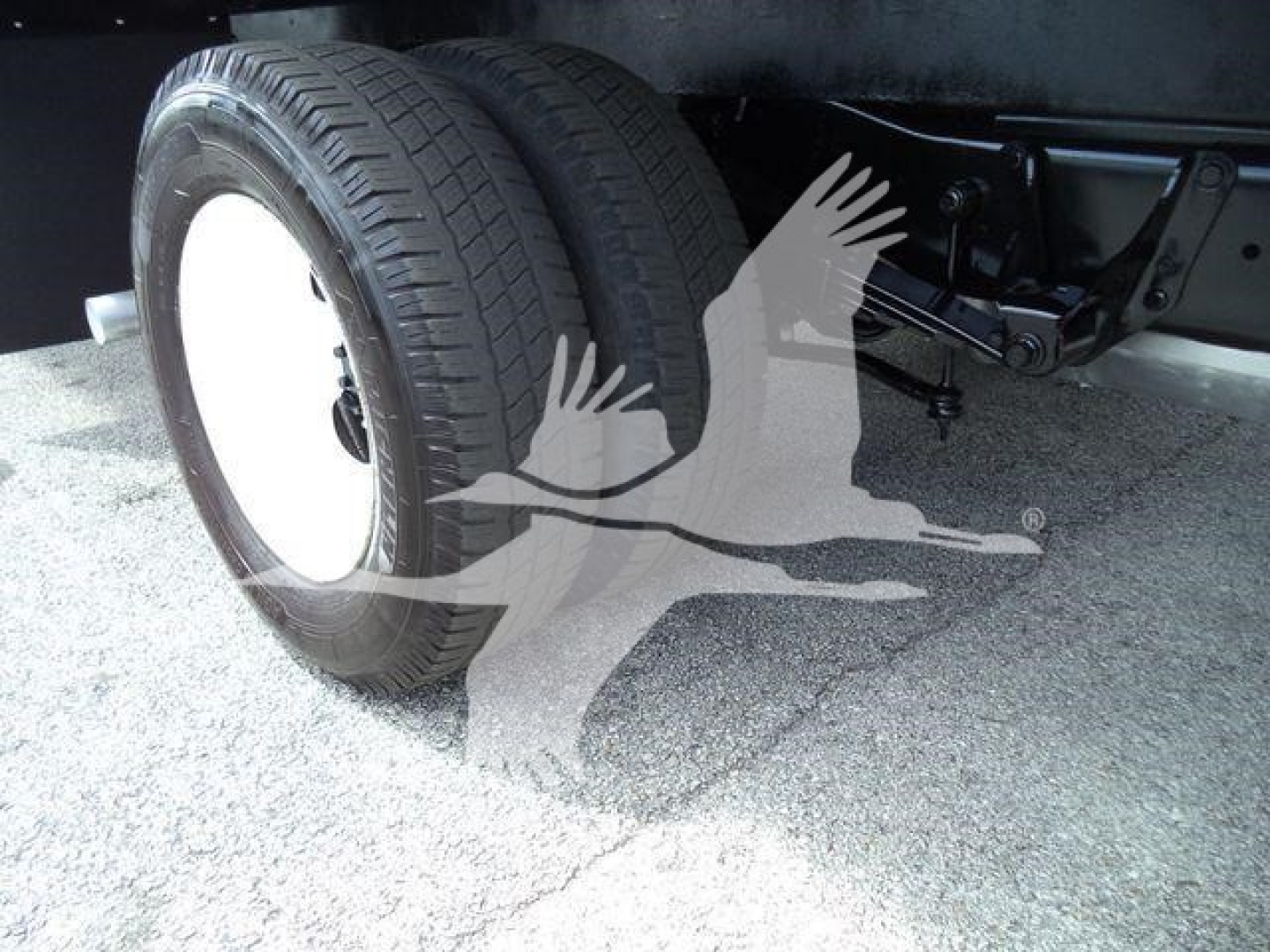 Ford E-450 box truck rear dual wheels and suspension visible under chassis.