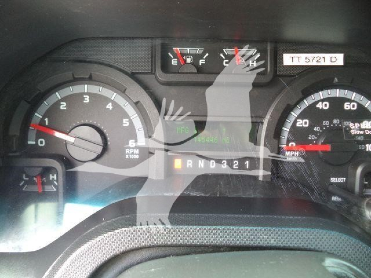 Dashboard view of 2011 Ford E450 showing instrument cluster, fuel and temperature gauges, gear indicator PRND321, and odometer area.