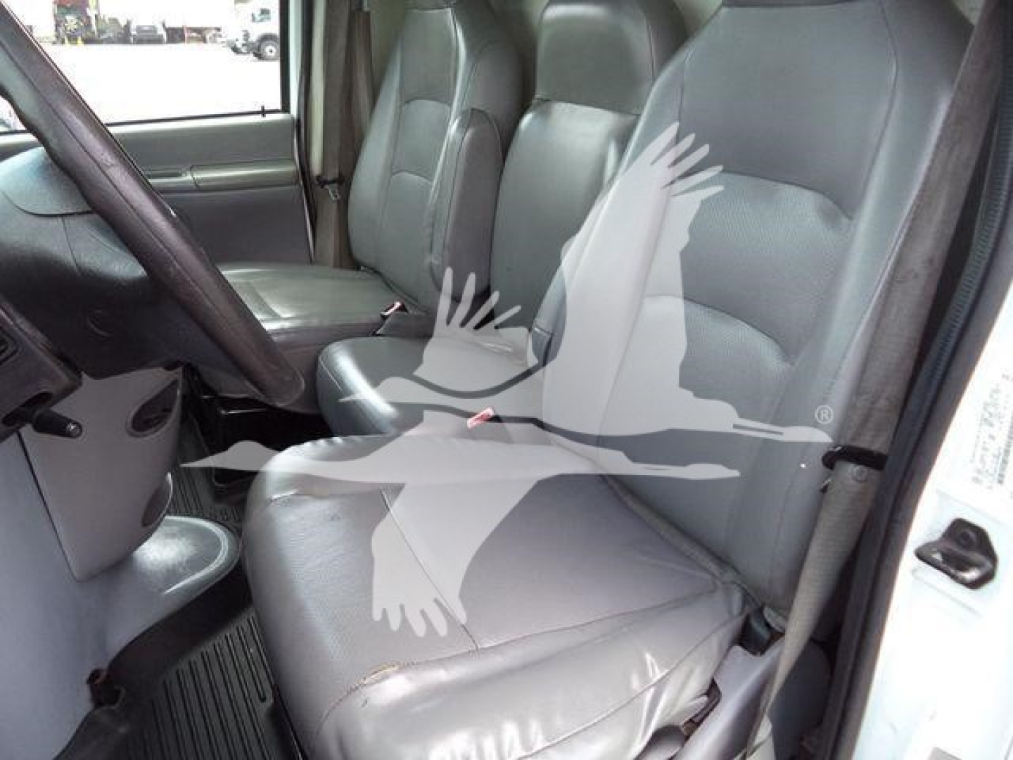 Ford E-450 box truck interior showing driver seat and front passenger seat with gray vinyl upholstery.