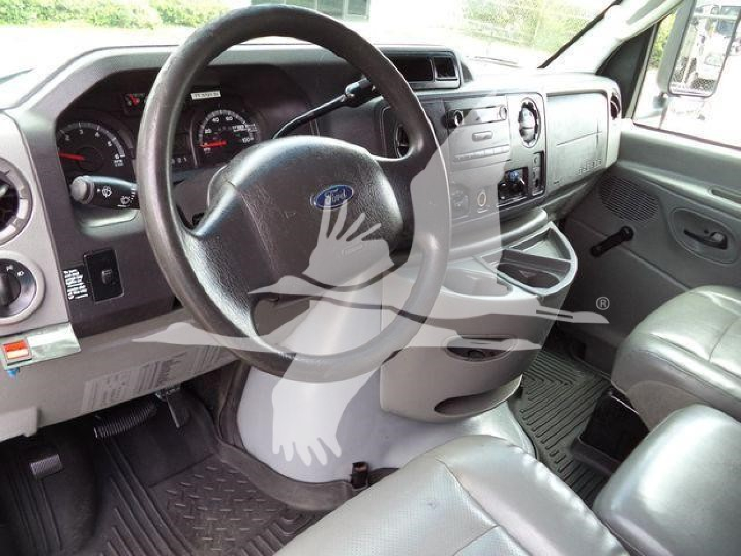Ford E450 interior with steering wheel, dashboard, and front seats; visible Ford emblem on steering wheel.