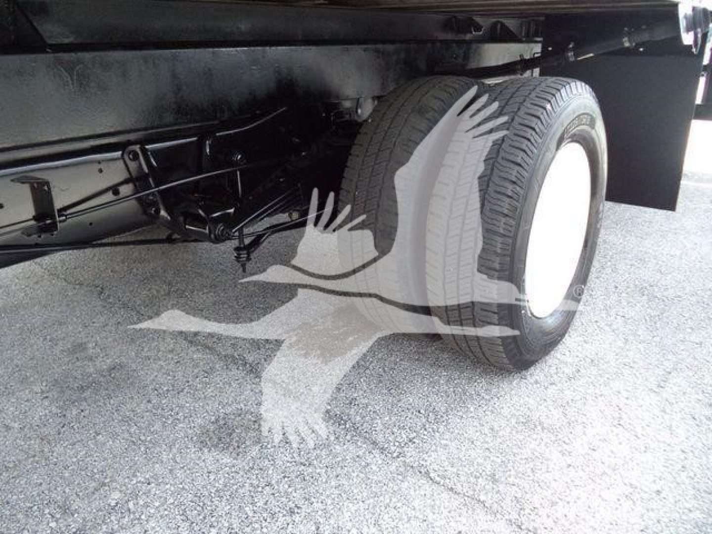 Ford E-450 chassis showing rear wheel and suspension undercarriage and underbody components.