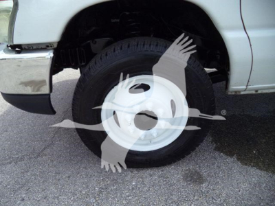 Ford E-450 wheel and front fender view showing steel white hubcap and tire in service condition.