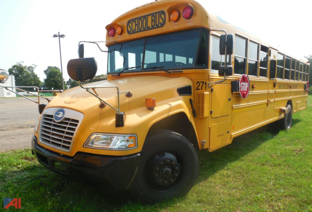 School bus with yellow paint showing 'SCHOOL BUS' sign, front grille, headlights, and side mirrors; 2018 Blue Bird Vision bus with stop sign and door open.
