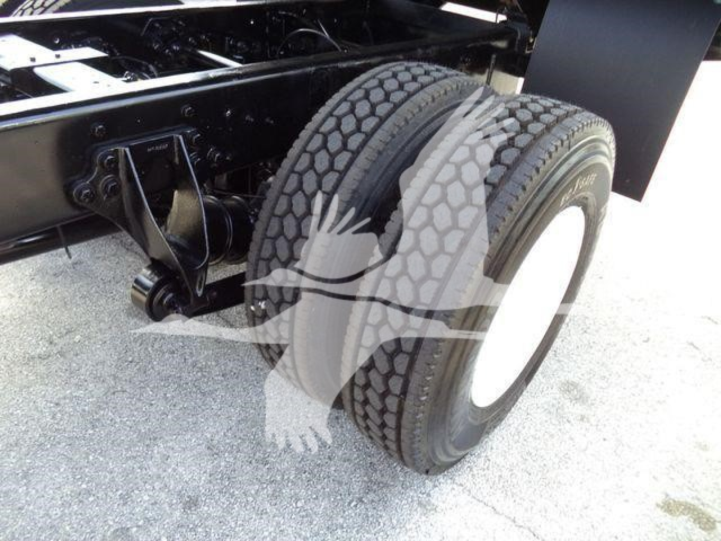 Tractor-trailer dual rear wheels and suspension in a truck chassis view showing wheel assembly and frame.