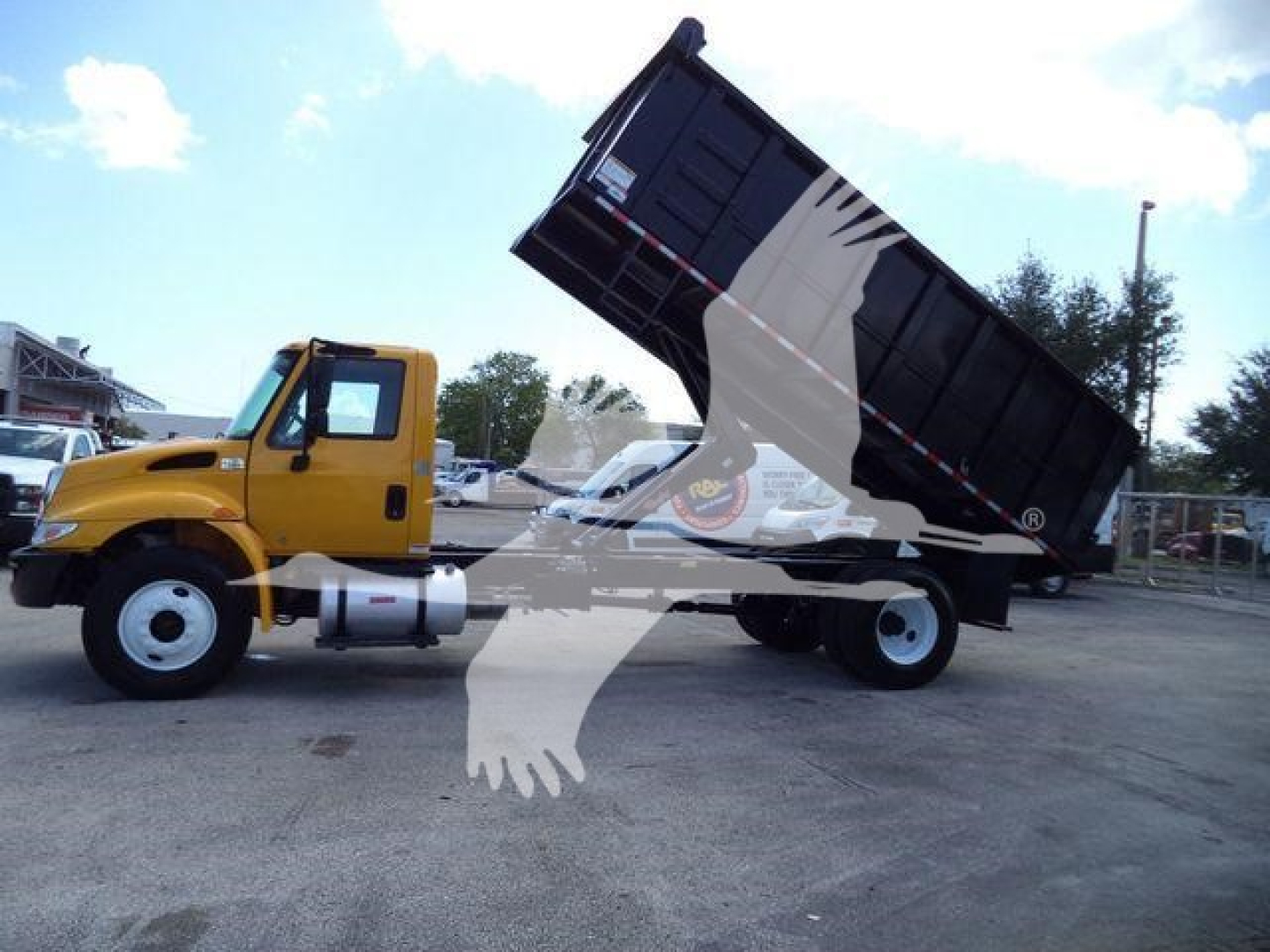 2019 International 4300 dump truck side view with cargo bed raised, yellow cab, black dump bed, in-service condition.