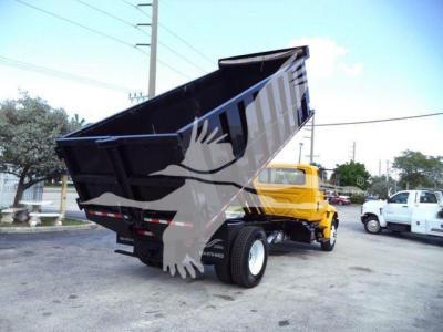 Dump truck with raised black bed and yellow cab, three-quarter rear view; no legible text visible on decals.