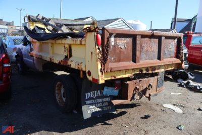 Dump truck bed of a 2006 Ford F550 Super Duty dump truck showing a rusted rear with a torn tailgate and debris in the bed.