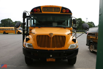 Front view of a yellow 2015 IC Corporation CE Series school bus showing grille, headlights, warning lights, and School Bus sign on top