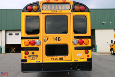 Rear view of a yellow IC Corporation CE Series school bus, showing the bus number 148, rear lights, and emergency door.