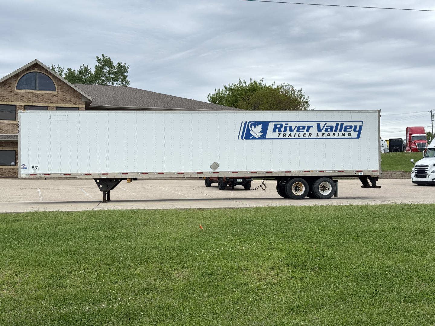 Trailer side view showing River Valley Transport Leasing logo on a white utility trailer with two axles.