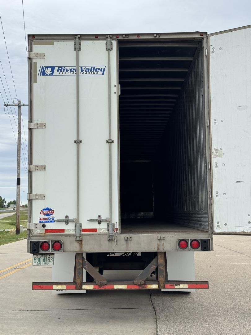 Trailer rear view showing open cargo area of a white River Valley trailer with back doors, taillights, and bumper.