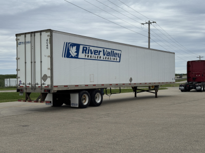 Trailer side view showing River Valley Trailer Leasing logo on a white utility trailer under a cloudy sky.