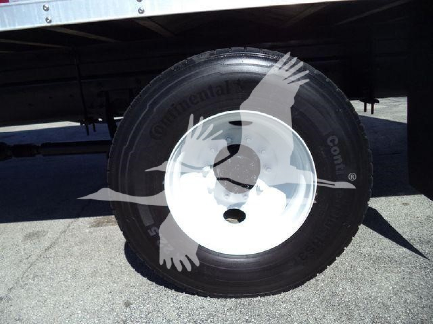 Wheel and tire close-up under a box truck showing Continental tire brand on the sidewall.
