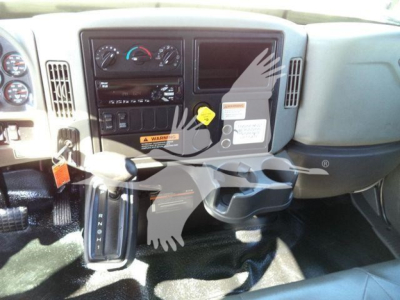 Interior of 2019 International 4300 cab showing dashboard, steering column, gear selector, and center console with controls and warning labels.