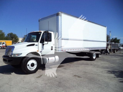 International truck box truck in service showing large white cargo box and cab with dual steer; stock number visible but no text legible from image.
