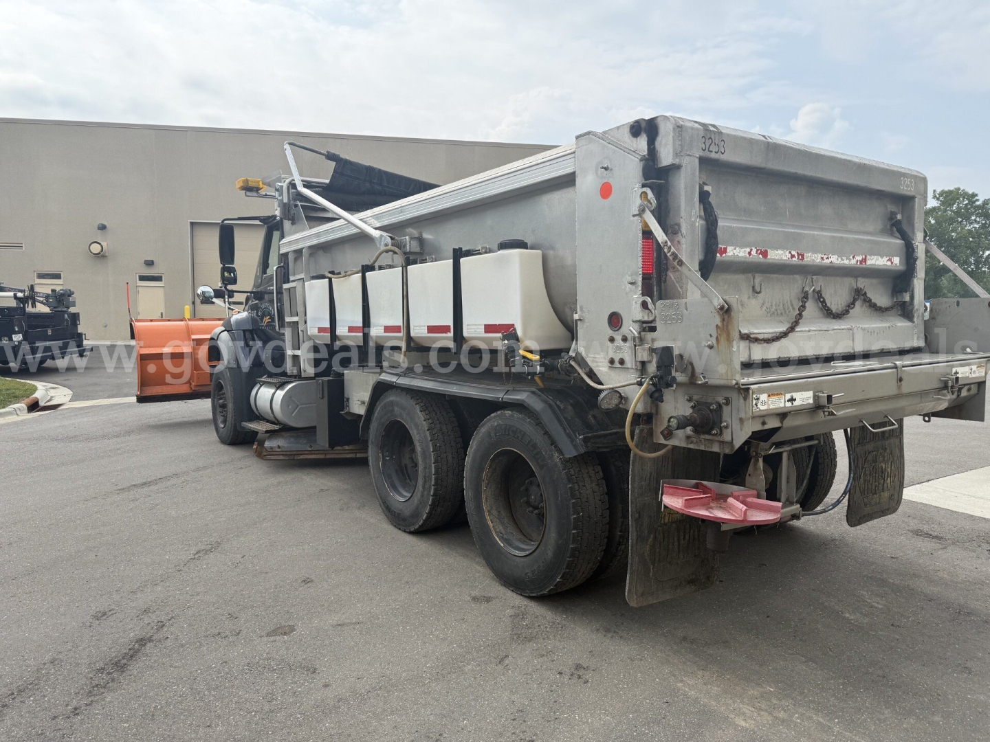 Truck bed side view showing rear dump dump bed of a 2007 International WorkStar 7600 plow truck with dual rear axles and plow setup.