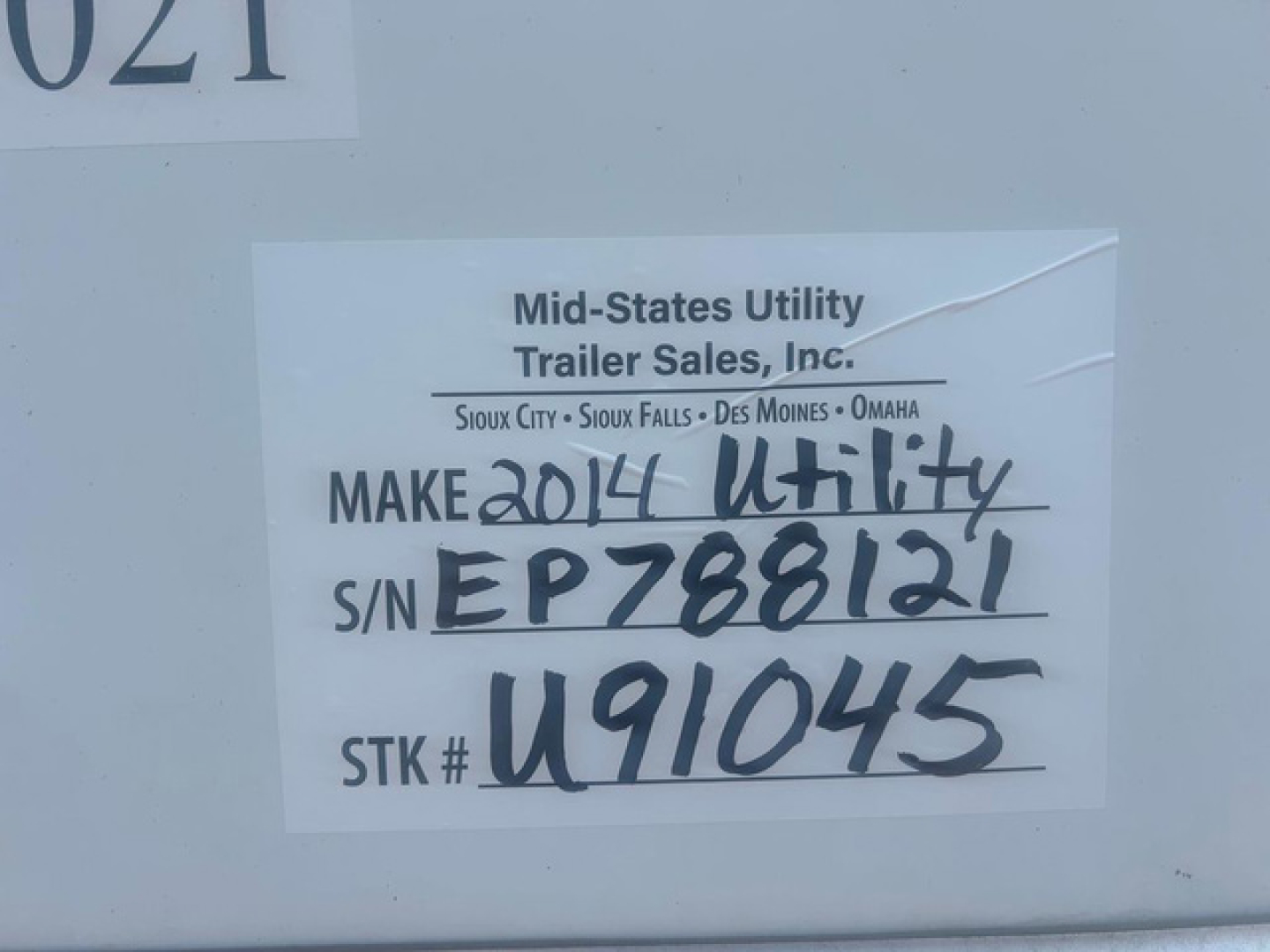 Tag on side of utility van showing Make 2014 Utility, S/N EP788121, STK # U91045, Mid-States Utility Trailer Sales, Inc.