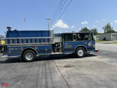 1994 Pierce Lance Pumper fire truck side view showing blue chassis, ladder racks, and wheel wells with equipment compartments.