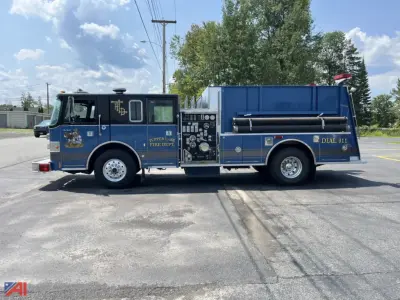 Side view of a blue Pierce Lance Pumper fire truck showing compartments and equipment panel, text and logos on doors and rear, and large water tank on the back.