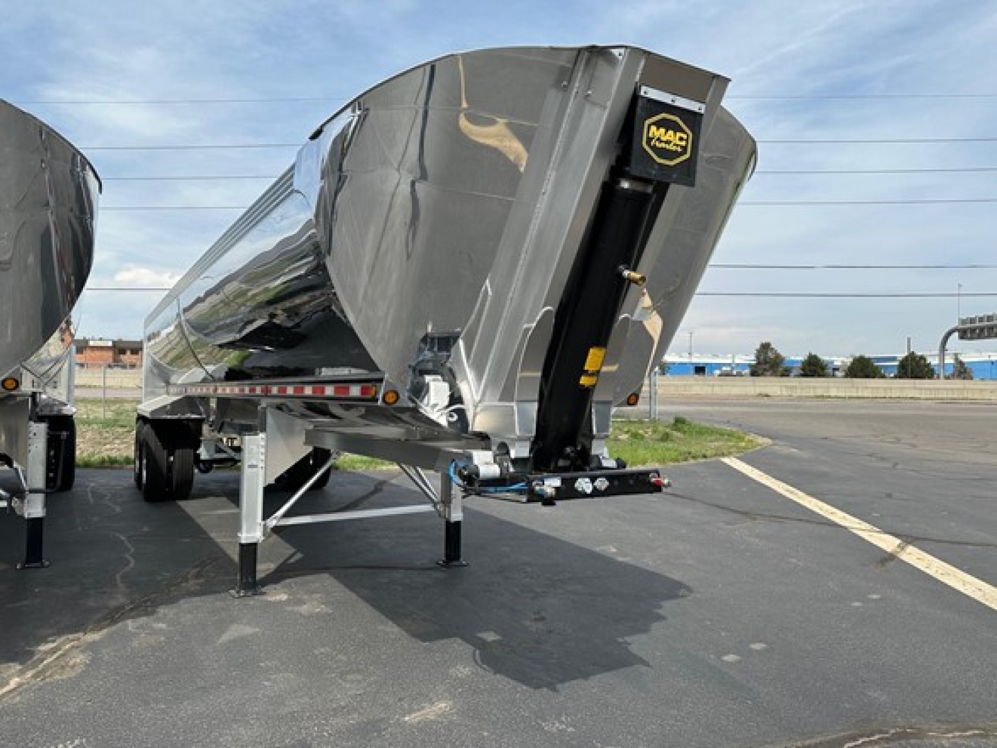 Trailer end dump showing Mac Macsimiser 1/2 round aluminum end dump with liner and IM secure hitch, side view from rear-left.