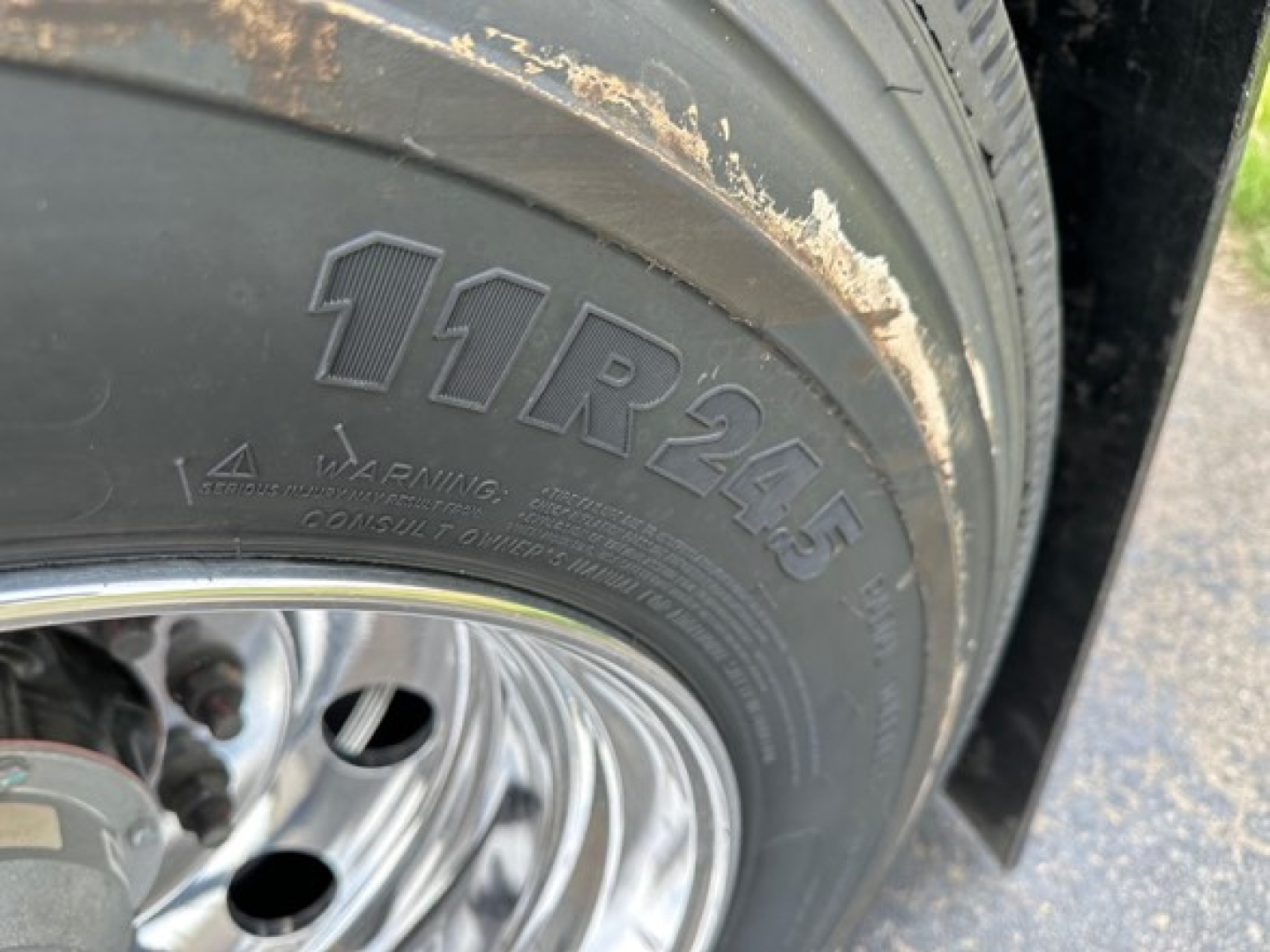 Trailer wheel and tire showing 11R24.5 tire size with polished steel rim on Mac Macsimiser 1/2 Round Alum End Dump.