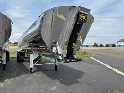 Trailer end dump showing Mac Macsimiser 1/2 round aluminum end dump with liner and IM secure hitch, side view from rear-left.