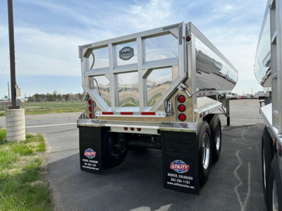 Dump trailer rear view showing aluminum end dump with MAC logo and dual rear lights, mud flaps, and dual axle wheels.
