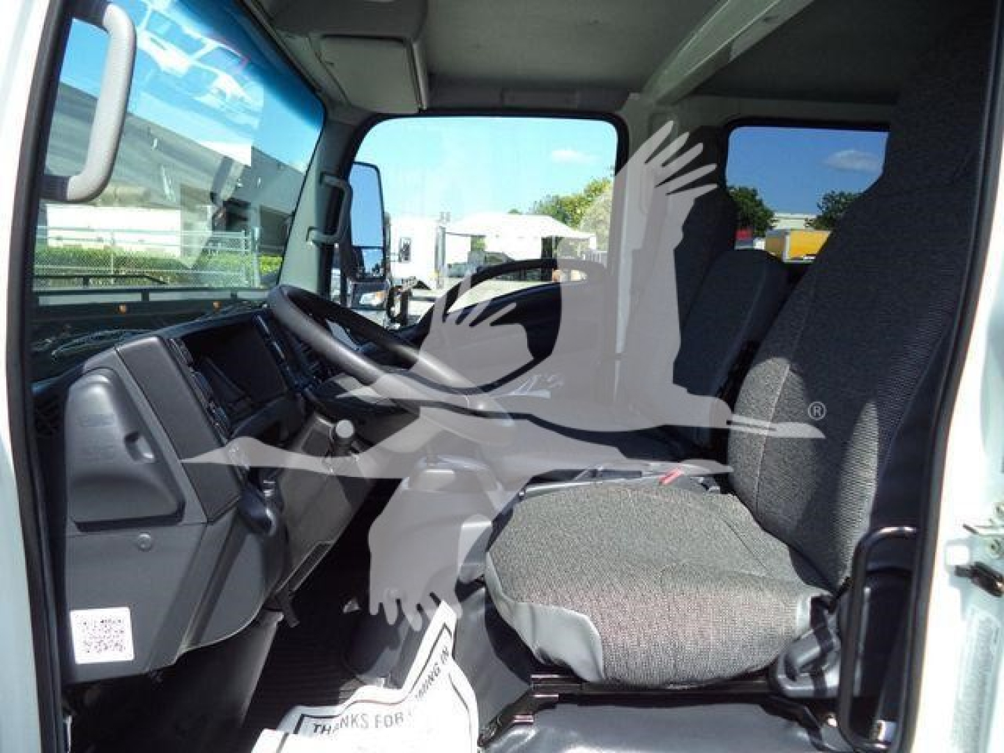 Isuzu NPR-HD cab interior showing driver seat and dashboard from open door.