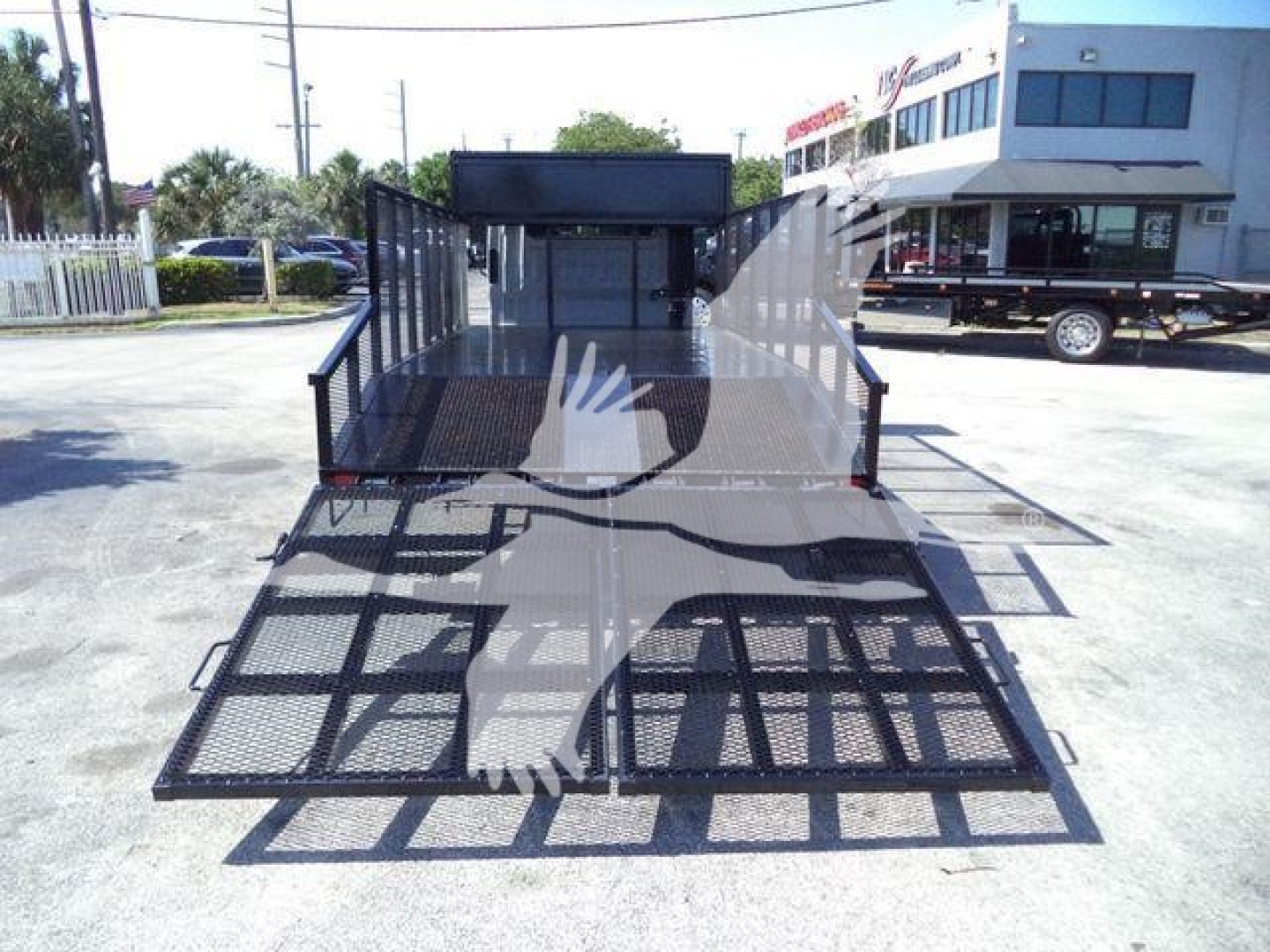 Isuzu NPR HD flatbed truck rear view showing a black steel ramped trailer/bed with mesh flooring and side rails.