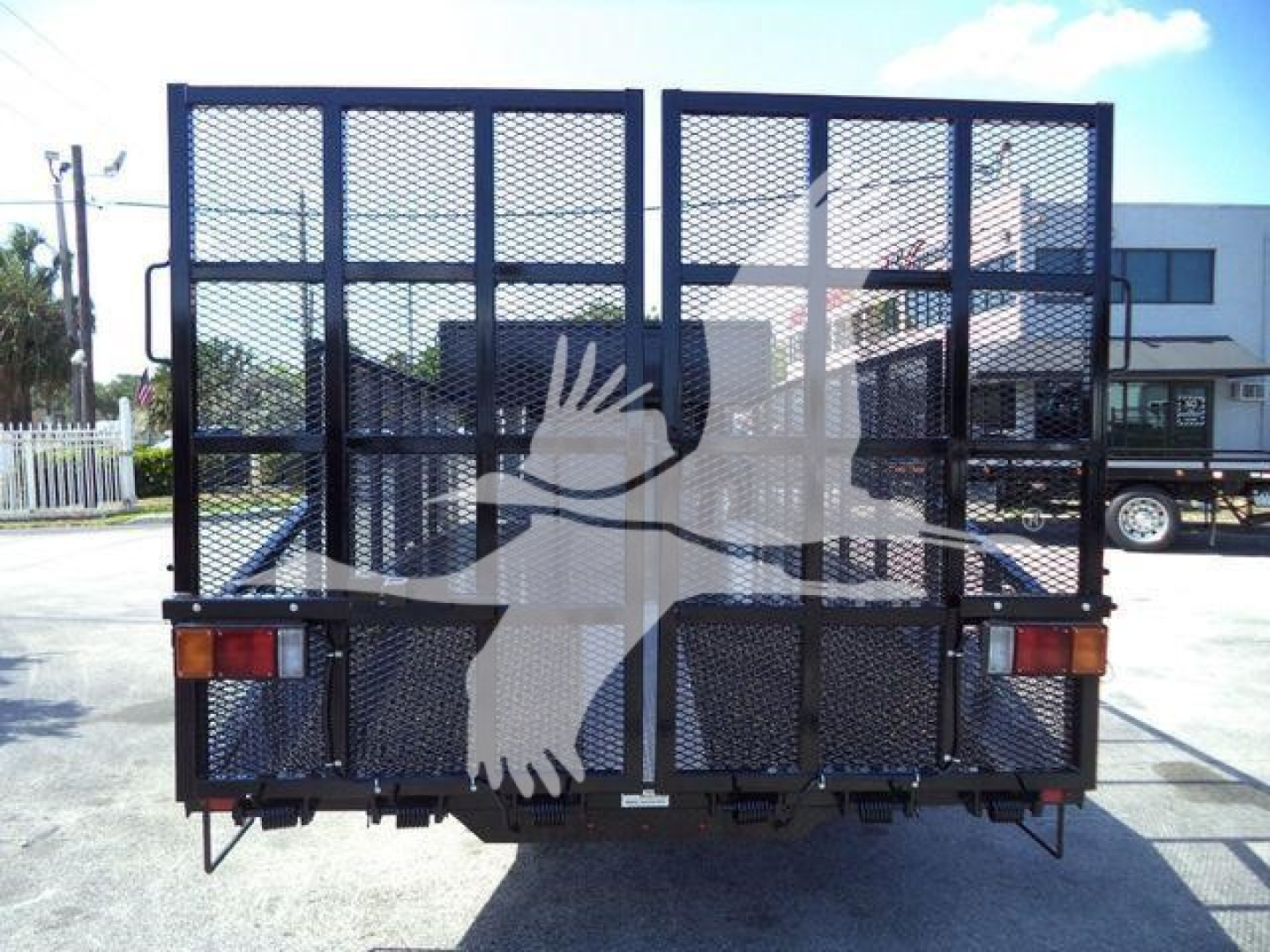 Isuzu NPR-HD truck rear with metal mesh gate and taillights.