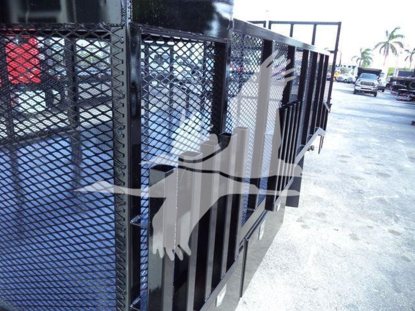 Isuzu NPR-HD landscape truck with side mesh gate cargo bed showing sturdy black metal panels and wheel area.