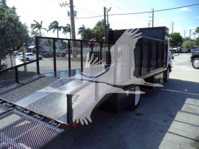 Isuzu NPR HD flatbed tow truck side view showing dual rear wheels and metal ramp bed.