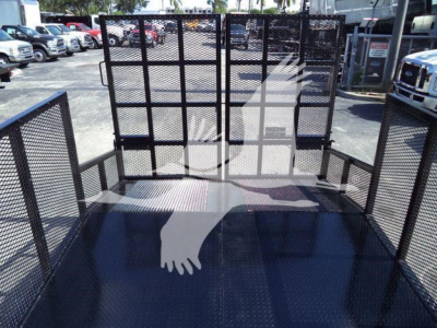 Isuzu NPR-HD truck bed with mesh gate sides and ramped access, open cargo area in a dealership lot.